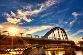 Looking at a modern bridge from underneath and the side with blue sky background