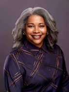 Photo of Erika Clark Jones smiling with silver hair and a dark purple shirt